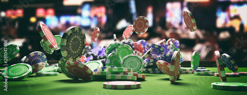 Leinwand Poster Poker chips falling on green felt roulette table, blur casino interior background
