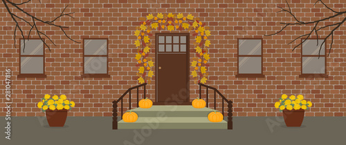 Autumn porch decor. There is a garland of autumn leaves; pumpkins and pots with yellow chrysanthemums on a brick facade background. Vector illustration