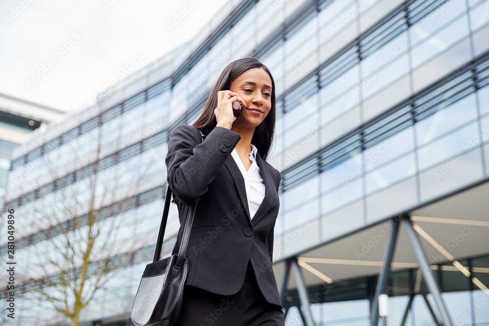 Businesswoman Commuting To Work Talking On Mobile Phone Outside Modern Office Building Businesswoman Commuting To Work Talking On Mobile Phone Outside Modern Office Building