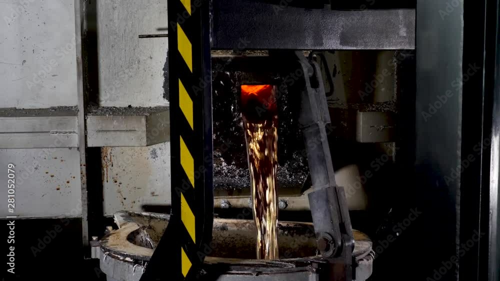 Liquid metal pouring out of a smelting machine into a cast. REAL TIME Liquid metal pouring out of a smelting machine into a cast. REAL TIME