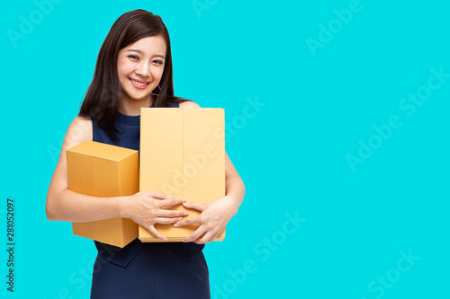 Young Asian entrepreneur holding parcel isolated on blue background, Teenager business owner online preparing to shipment delivery © comzeal