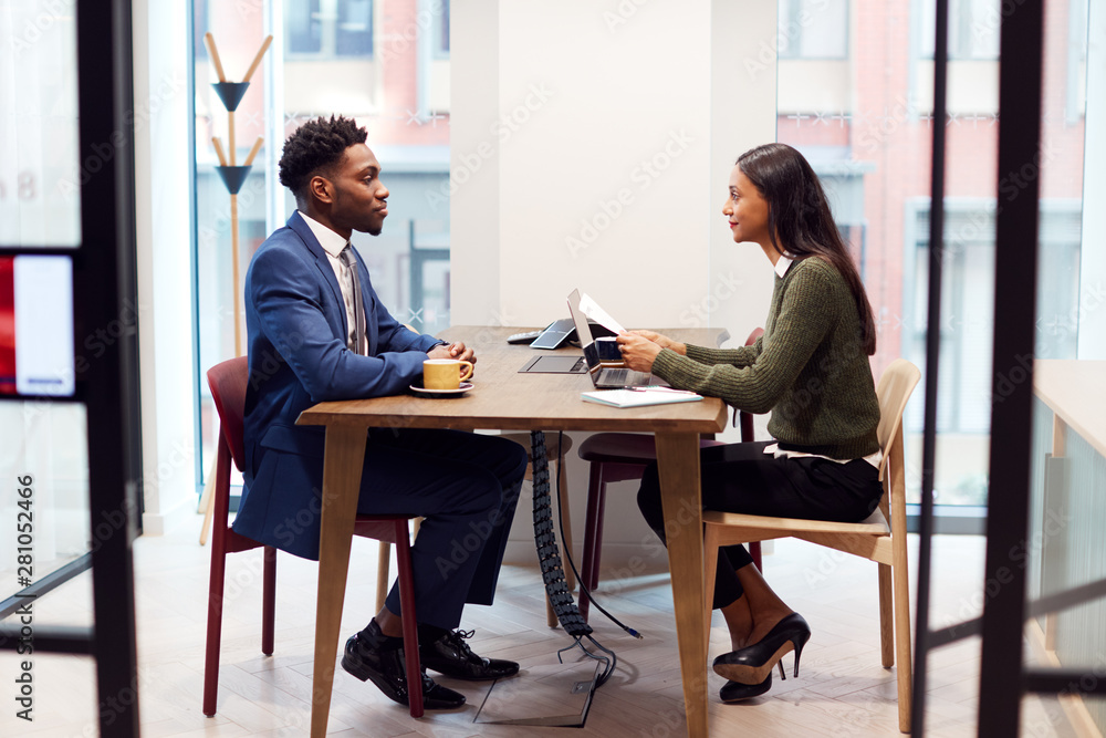 Businesswoman Interviewing Male Job Candidate In Meeting Room Businesswoman Interviewing Male Job Candidate In Meeting Room