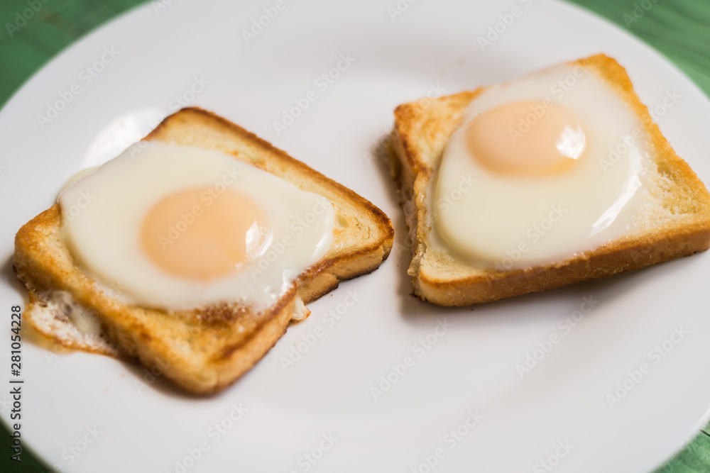 Toast with fried egg on a white plate. Sandwich with chicken egg. Snack, breakfast. Toast with fried egg on a white plate. Sandwich with chicken egg. Snack, breakfast.