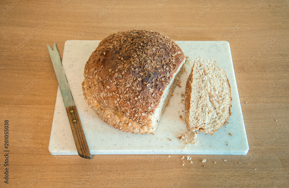 Loaf of bread and bread knife on a bread board. Loaf of bread and bread knife on a bread board.