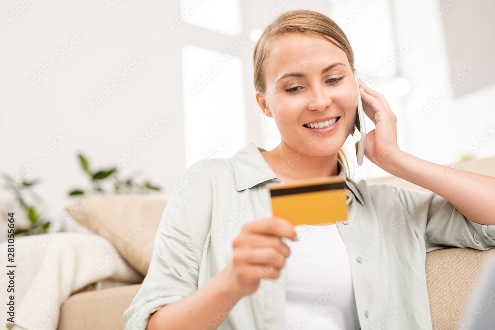 Happy young client of online shop consulting with manager on the phone Happy young client of online shop consulting with manager on the phone