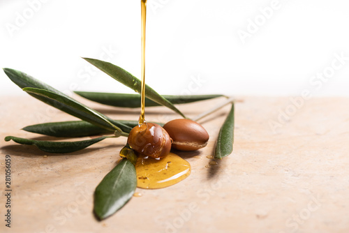 argan oil pouring over argan seeds photo