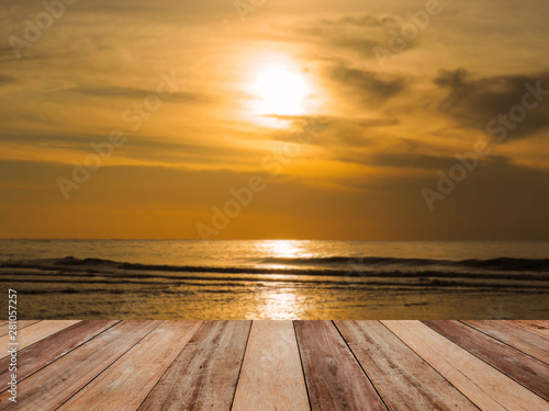 Wood table top over golden hour sunrise summer sea background.