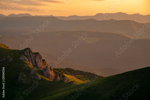Sunset over the mountains. The warm sunlight is hitting the cliffs