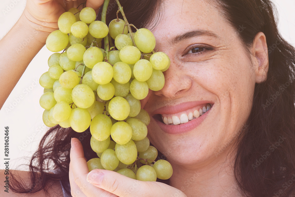 portrait of attractive caucasian smiling woman isolated on white studio shot with green grapes portrait of attractive caucasian smiling woman isolated on white studio shot with green grapes