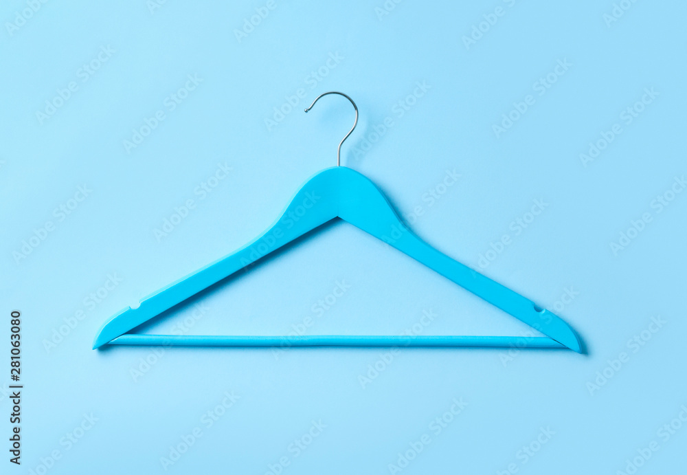 Top view flat lay single white wooden hanger blue pastel background. Top view flat lay single white wooden hanger blue pastel background.