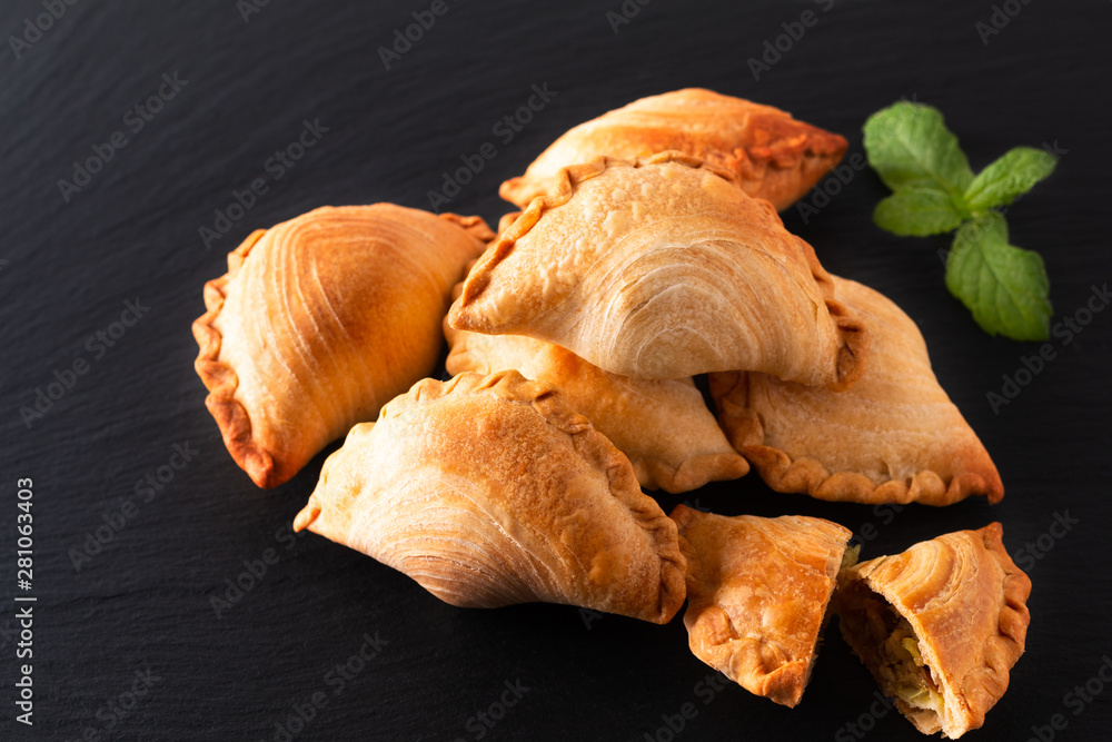 South east Asia origin food concept homemade chicken Curry puffs on black slate stone background with copy space