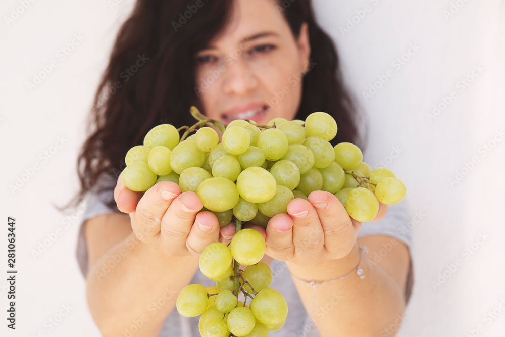 Beautiful woman, holding fresh green grape in handful, isolated on white background Beautiful woman, holding fresh green grape in handful, isolated on white background
