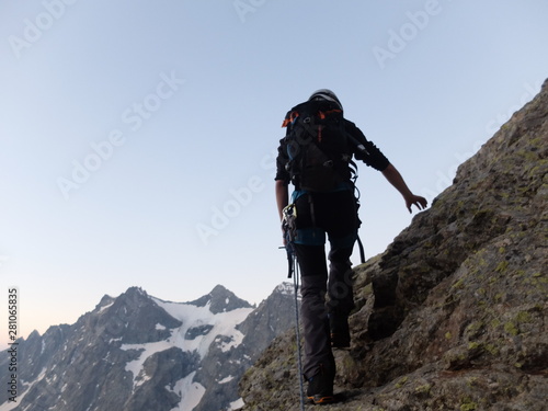 silhouette de jeune alpiniste escaladant en haute montagne avec neige et glacier