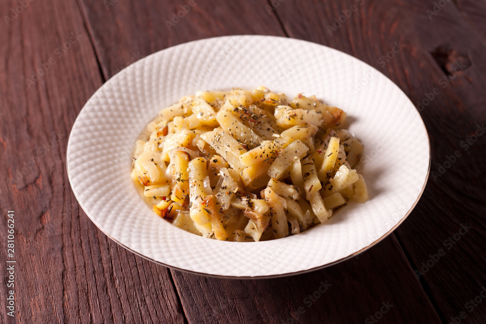 Fried potatoes with onions and seasonings on a white plate Fried potatoes with onions and seasonings on a white plate
