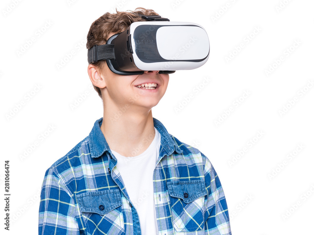 Happy teen boy wearing virtual reality goggles watching movies or