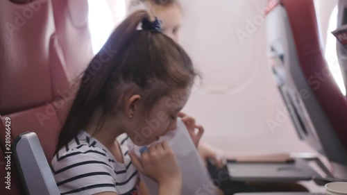 Little girl on the plane vomited in a paper bag. A Little girl feels bad in the cockpit. The fear of flying. photo