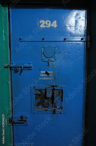 Door of a cell for prisoners with locker, door latch and peephole