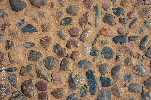 pavement made of colored rounded stone on a sandy base