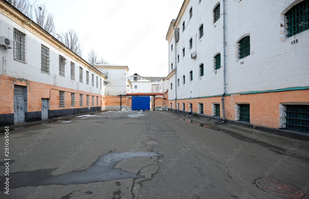 Prison yard, windows, bars of detention facility 