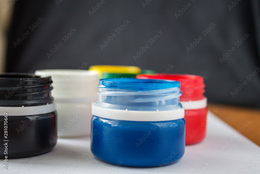 Paint jars and sketchbook on a wooden table. Learning to draw. Paints gouache Paint jars and sketchbook on a wooden table. Learning to draw. Paints gouache