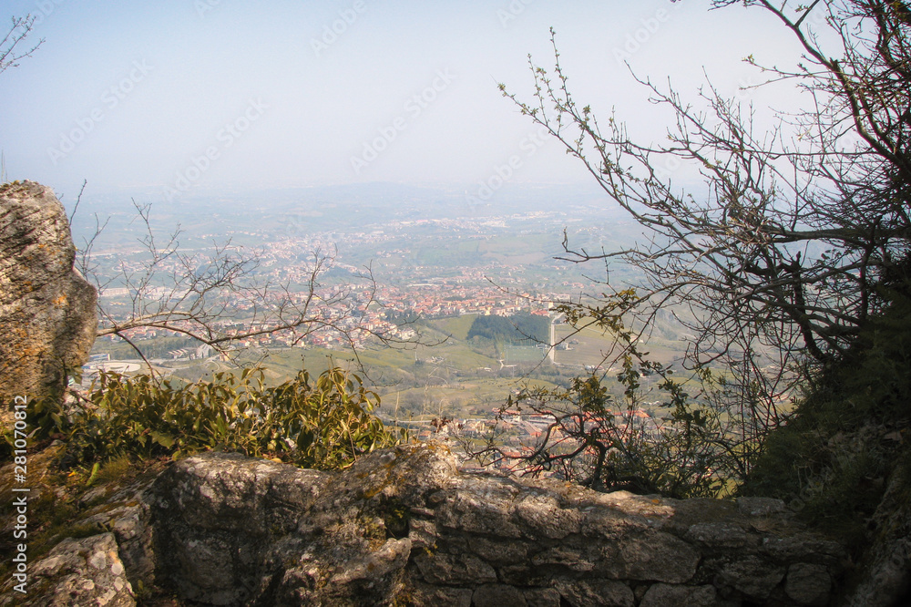 View of the city from the fortress wall of San Marino. The Republic of San Marino to Italy, the city wall and houses at the bottom.