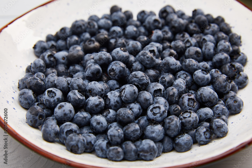plate with delicious organic blueberries on white wooden table plate with delicious organic blueberries on white wooden table