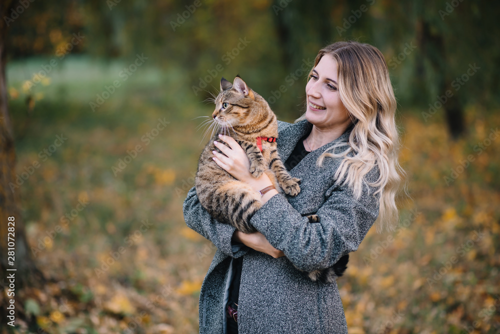 Beautiful young couple resting in autumn park. autumn concept. Loving couple resting with their cat. Beautiful young couple resting in autumn park. autumn concept. Loving couple resting with their cat.
