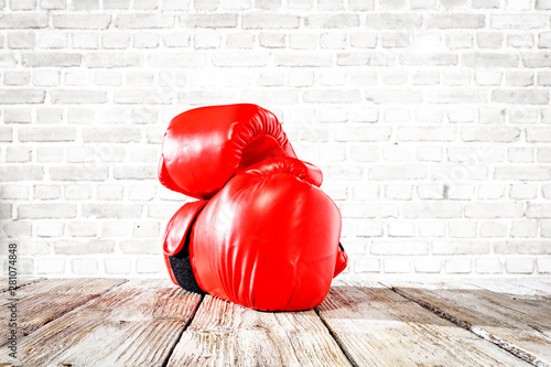 Red boxing gloves on wooden top background. © magdal3na