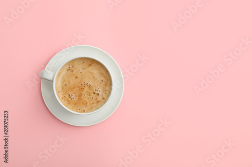 Cup of coffee on pink background, top view. Space for text