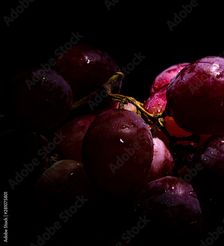 Red grapes sprinkled with waterdrops in dark setting
