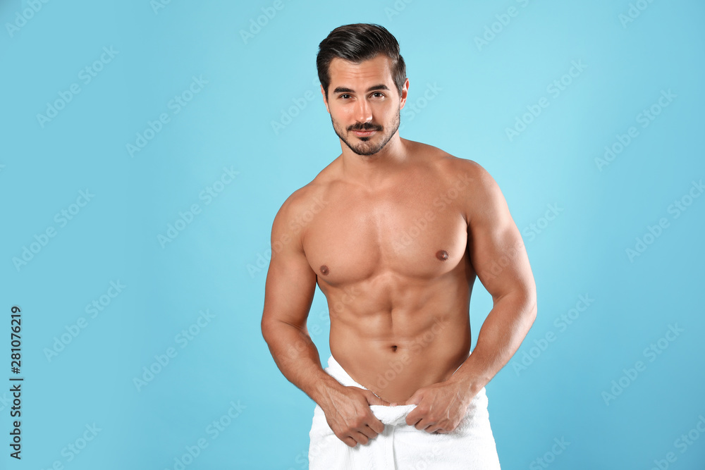 Young man with slim body on light blue background