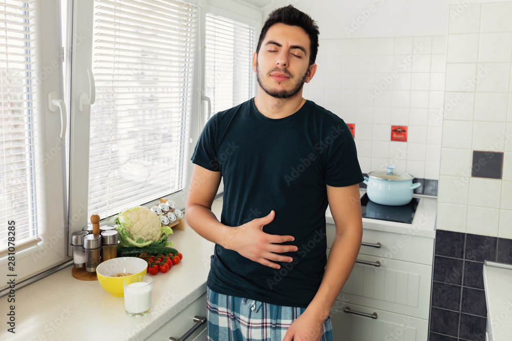 The young man no longer experiences pain and discomfort in the stomach, as he drinks vegetable milk. He has lactose intolerance. The young man no longer experiences pain and discomfort in the stomach, as he drinks vegetable milk. He has lactose intolerance.