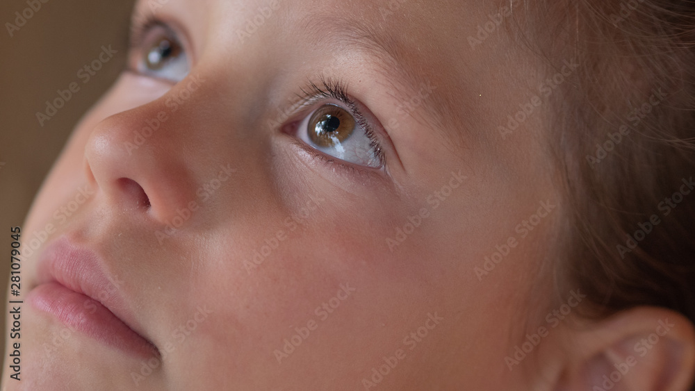 Authentic extra close up shot of cute serious little girl is looking up outside her house in the morning. Authentic extra close up shot of cute serious little girl is looking up outside her house in the morning.