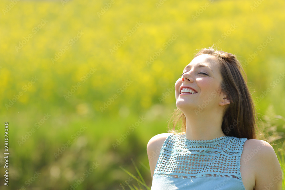 Happy woman resting breathing fresh air in a field Happy woman resting breathing fresh air in a field