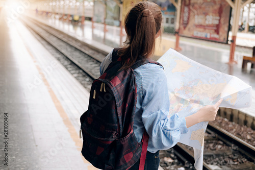 Traveler Asian woman direction and looking on location map while spending holiday trip and waiting train at train station, Female tourist backpacker enjoy journey. Lifestyle women travel concept