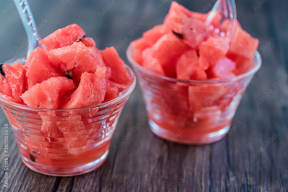 Dessert from sliced fresh watermelon in glass cups on a gray background. Dessert from sliced fresh watermelon in glass cups on a gray background.