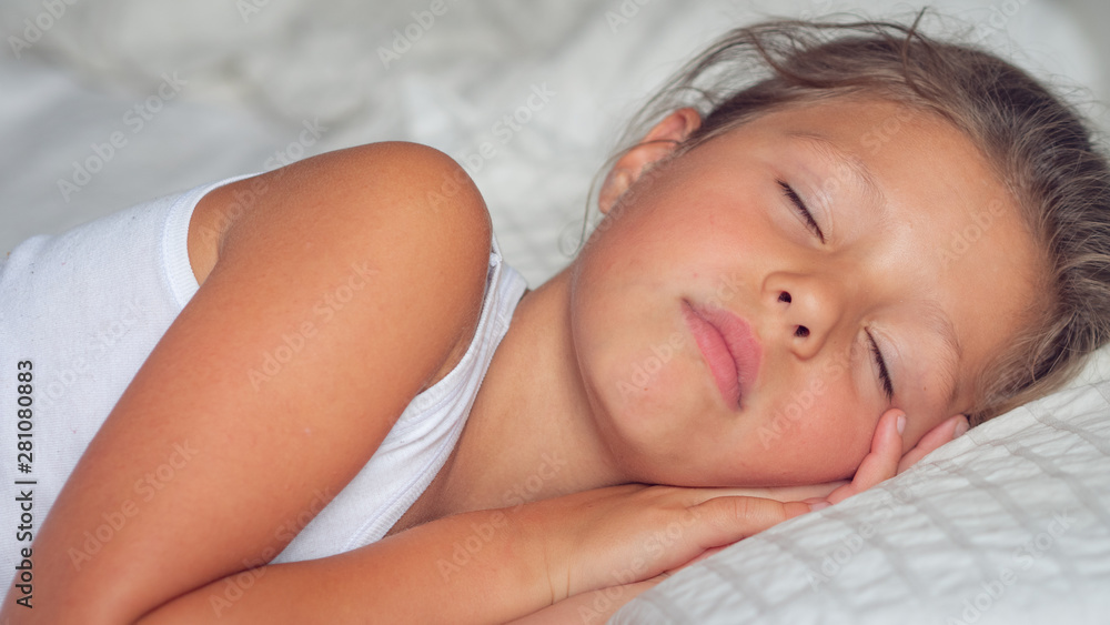 Authentic shot of cute little girl is sleeping peacefully in her bed with white sheet and pillow in the morning. Authentic shot of cute little girl is sleeping peacefully in her bed with white sheet and pillow in the morning.