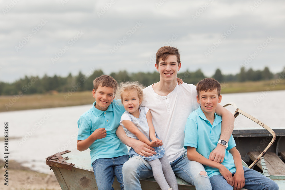 Group of happy cheerful beautiful children sitting on boat in park, outdoor Group of happy cheerful beautiful children sitting on boat in park, outdoor