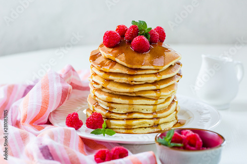 Homemade pancakes with maple syrup and raspberries