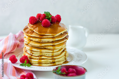 Homemade pancakes with maple syrup and raspberries