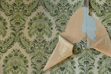 wall with torn wallpaper in old house