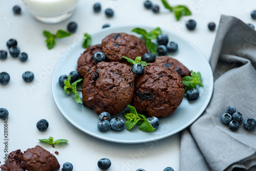 Chocolate cookies with chocolate chips and blueberry on gray wooden background. Summer food. Soft focus.