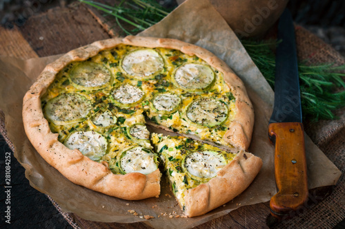 Cuadro en lienzo Homemade courgette and goat cheese pie on a dark rustic wooden board background