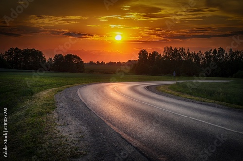 Vivid orange tropical sunset with curving road