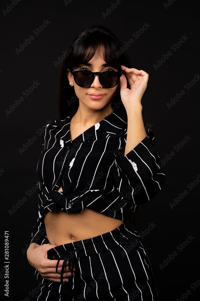 Young business girl in a black suit posing for a photo on a black background. Young business girl in a black suit posing for a photo on a black background.