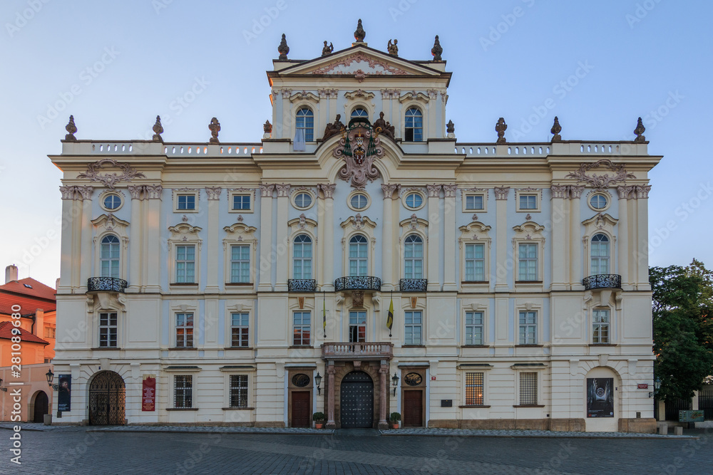 Archbishop Palace near the entrance to the Prague Castle on Hradschin Square. Historic white building with decorations in the evening sun