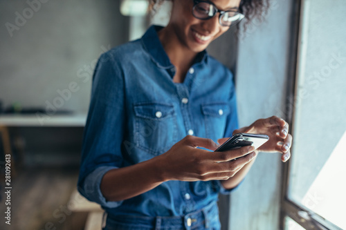 Female entrepreneur using smart phone in office