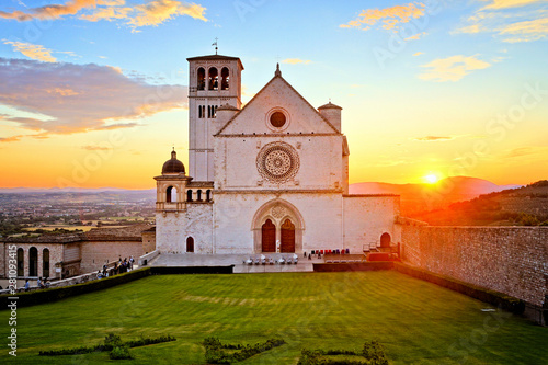 Basilica of San Francis of Assisi with beautiful setting sun behind, Italy photo