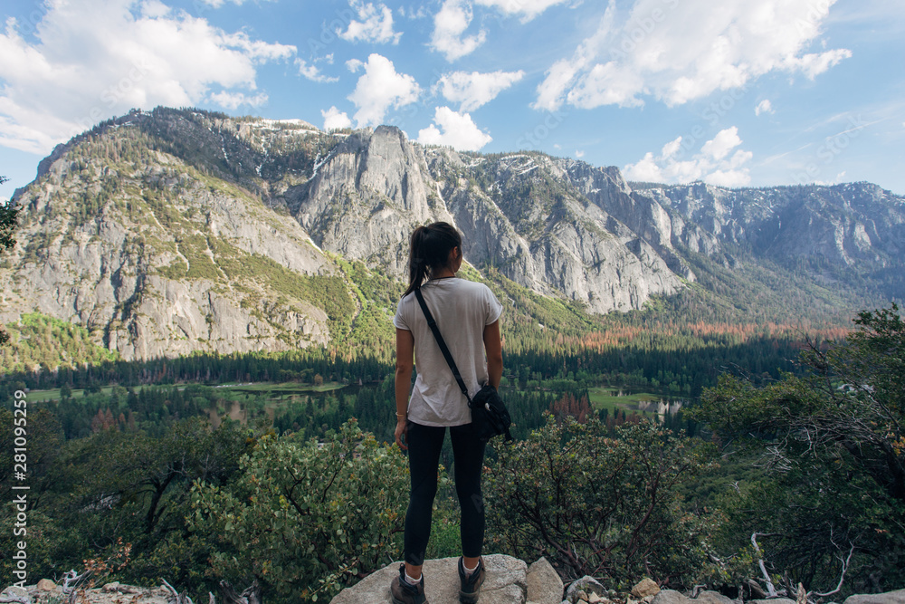 A female hiker looks out over the iconic Yosemite valley.