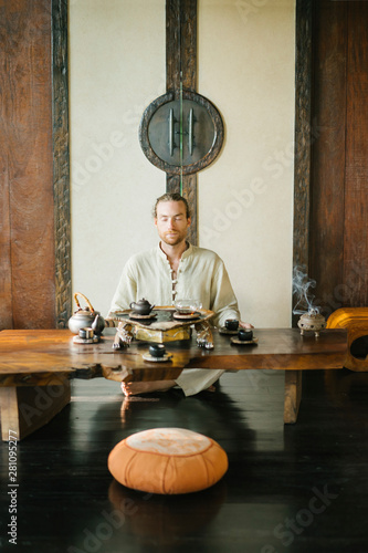 Meditating master conducting tea ceremony photo